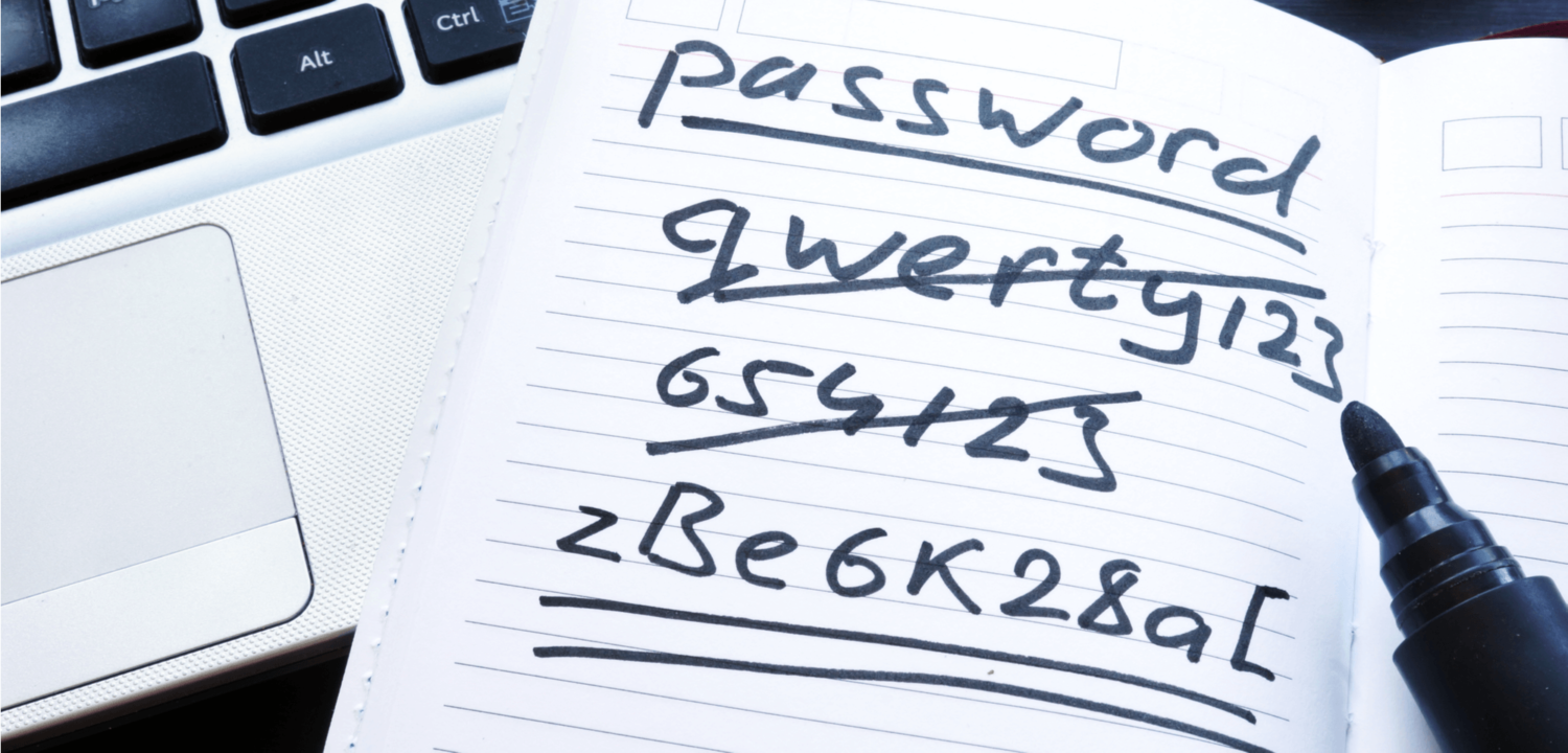 Notepad with the title password. Various passwords such as qwerty123 and 654123 are crossed out. A password zBe6K28a[ is underlined twice. The notebook is on a laptop.